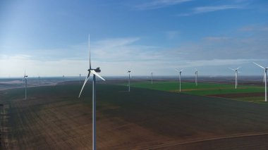 Rüzgâr türbinleri insansız hava aracının bakış açısından sahada duruyor.