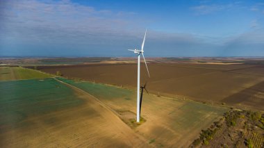 Rüzgâr türbinleri insansız hava aracının bakış açısından sahada duruyor.