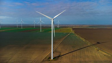 Rüzgâr türbinleri insansız hava aracının bakış açısından sahada duruyor.