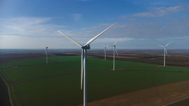 Rüzgâr türbinleri insansız hava aracının bakış açısından sahada duruyor.