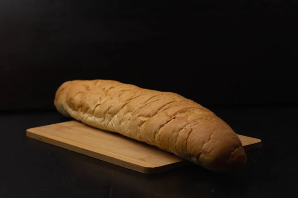 Beyaz Ekmek Tahta Bir Arka Planda Kesme Tahtasının Üzerinde Yatıyor — Stok fotoğraf