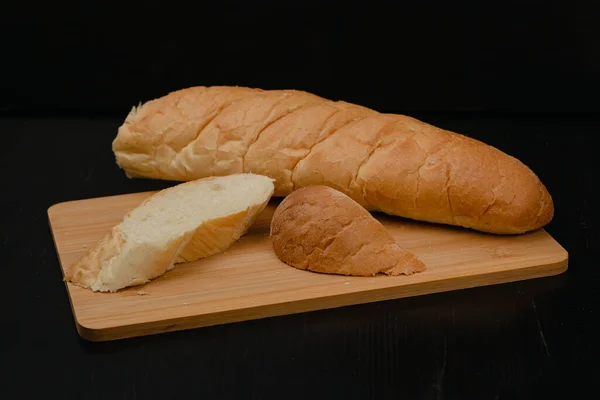 Κομμένο Άσπρο Ψωμί Βρίσκεται Μια Σανίδα Κοπής Ξύλινο Φόντο — Φωτογραφία Αρχείου