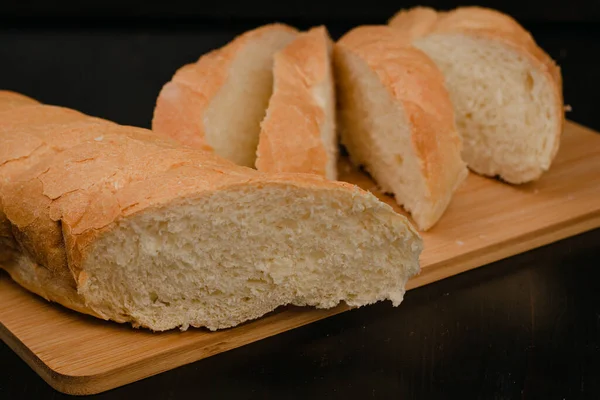 Pão Branco Fatiado Está Uma Tábua Corte Fundo Madeira — Fotografia de Stock