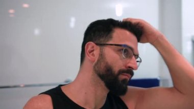 Banyoda tıraş olan bir adam işe hazırlanıyor.