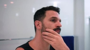 Banyoda tıraş olan bir adam işe hazırlanıyor.