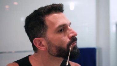 Banyoda tıraş olan bir adam işe hazırlanıyor.