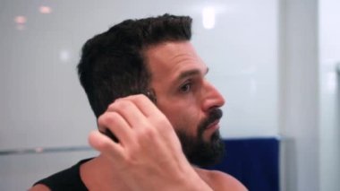 Banyoda tıraş olan bir adam işe hazırlanıyor.
