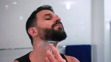 Banyoda tıraş olan bir adam işe hazırlanıyor.