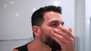 Banyoda tıraş olan bir adam işe hazırlanıyor.