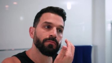 Banyoda tıraş olan bir adam işe hazırlanıyor.