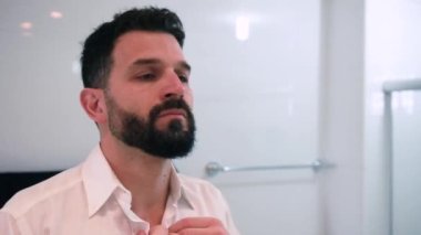 Banyoda tıraş olan bir adam işe hazırlanıyor.
