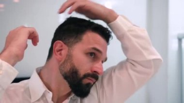 Banyoda tıraş olan bir adam işe hazırlanıyor.