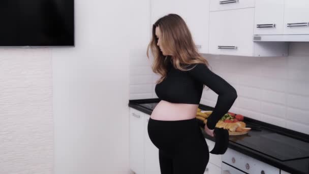 Mujer Embarazada Joven Que Pone Una Banda Apoyo Maternidad Estar — Vídeos de Stock
