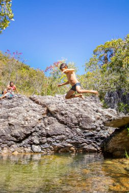 Brezilyalılar, 2025 Temmuz 'unda Brezilya' nın Cavalcante şehrinde güzel bir nehre atlayan çocukları izlerken eğleniyorlar..