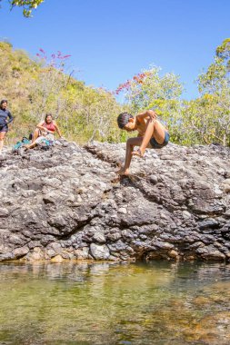 Brezilyalılar, 2025 Temmuz 'unda Brezilya' nın Cavalcante şehrinde güzel bir nehre atlayan çocukları izlerken eğleniyorlar..