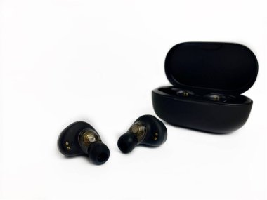 Yakın plan kablosuz siyah kulaklıklar ve beyaz arka plan şarjı.