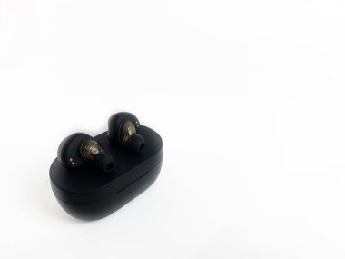 Yakın plan kablosuz siyah kulaklıklar ve beyaz arka plan şarjı.