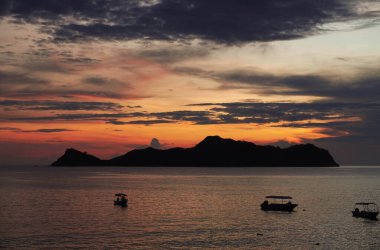 Pulo Dua Balantak Tepesi 'nin güzel manzarası, gün doğumunda adanın manzarası ve Endonezya' nın Merkez Sulawesi bölgesindeki Banggai bölgesinde bulunan balıkçı tekneleri.