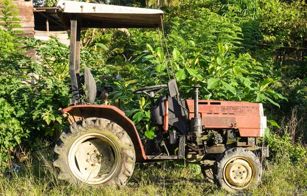 old rusty tractor in red color in field