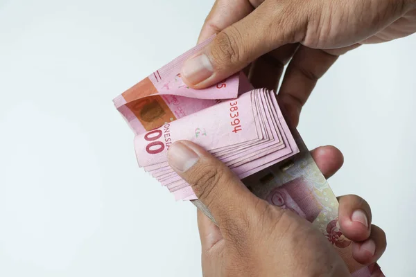 stock image the process of counting Indonesian rupiah money on a white background