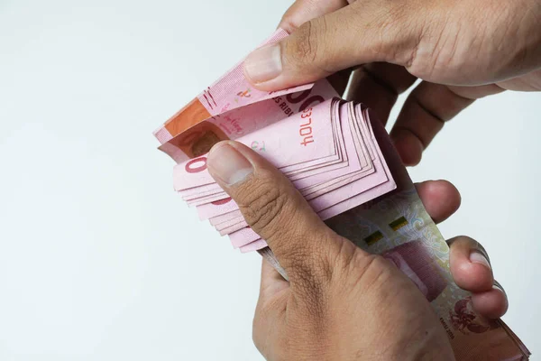 stock image the process of counting Indonesian rupiah money on a white background