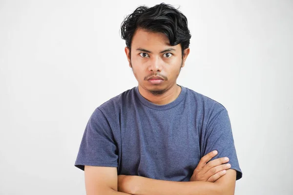 stock image Image of angry displeased asian man standing and crossing arms with outfit casual isolated over white background wall. Looking camera.