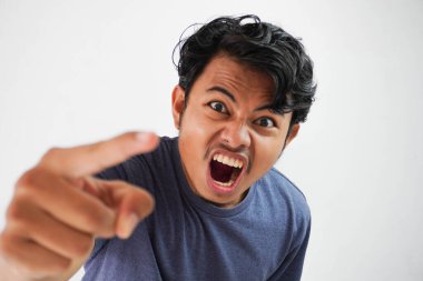 Kızgın, agresif, Asyalı, tişört giyen, denizci renginde vahşi bir ifadeyle bağıran ve parmağı kırılmış genç bir adam.