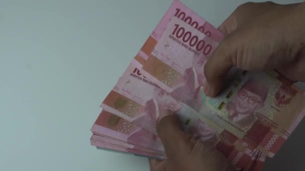 Рука Людини Підраховує Сто Тисяч Рупій Індонезійські Гроші Білому Тлі — стокове відео