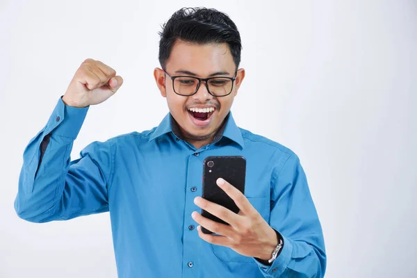 Дуже Збуджений Молодий Азіатський Працівник Окулярах Тримає Телефон Згорнутими Кулаками — стокове фото