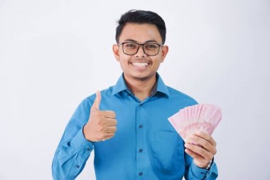 Gülümse ya da gözlüklü mutlu Asyalı çalışan elinde para olan beyaz arka planda mavi gömlek giyen.
