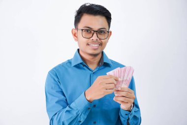 Gülümse ya da gözlüklü mutlu Asyalı çalışan elinde para olan beyaz arka planda mavi gömlek giyen.