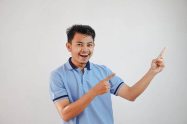 Gülümseyen Asyalı adam, beyaz arka planda mavi tişört giyiyor.