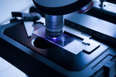 Laboratuvarda metal mercekli mikroskobun yakın çekimi. araştırma ekipmanları kapsamı biyoteknoloji