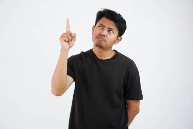 amazed young asian man wearing black t shirt standing point finger up isolated on white background