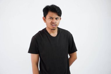 annoyed young Asian man wearing black t shirt stand doubt face feels dizzy isolated on white background