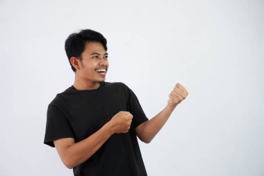 young Asian man smile gesture pull rope heavy wearing black t shirt isolated on white background. copy space