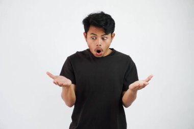 amazed or shocked young asian man open hand with open mouth wearing black t shirt isolated on white background