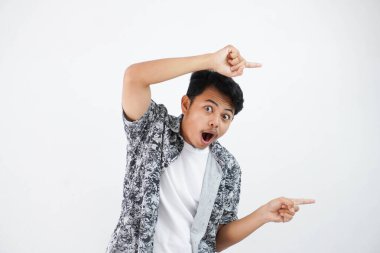shocked asian man with fingers pointing to the side wearing black shirt isolated on white background