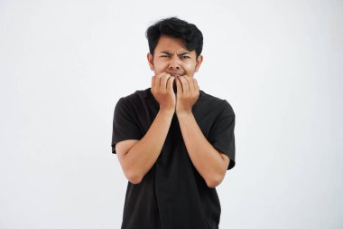 scared young Asian man black t shirt gesture afraid something isolated on white background