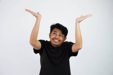 Young Asian man in black casual clothes attempt to hold something heavy from above. isolated on white background