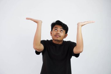 Young Asian man in black casual clothes attempt to hold something heavy from above. isolated on white background