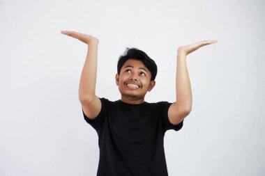 Young Asian man in black casual clothes attempt to hold something heavy from above. isolated on white background