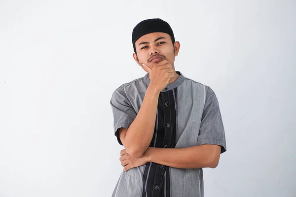 thinking young asian muslim man holding chin thinking gesture, looking for idea wearing grey muslim clothes isolated on white background