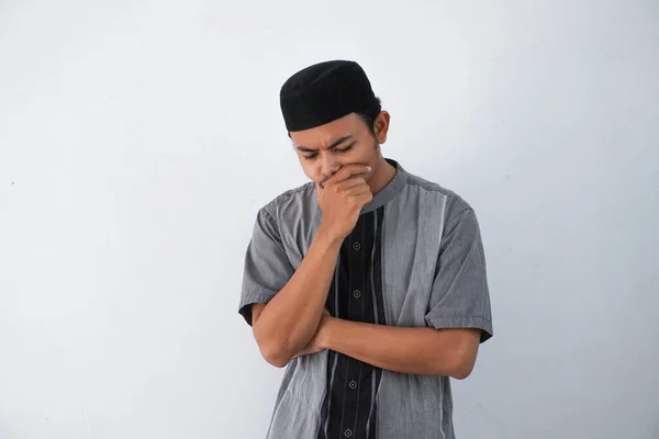 thinking young asian muslim man holding chin thinking gesture, looking for idea wearing grey muslim clothes isolated on white background