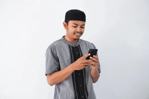 Szczęśliwy Lub Uśmiechnięty Młody Muzułmanin Azjatycki Trzyma Telefon Komórkowy Nosząc — Zdjęcie stockowe