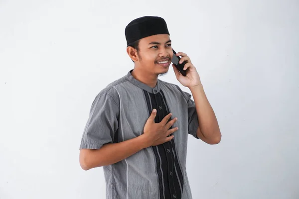 Uśmiechnięty Młody Azjatycki Muzułmanin Trzyma Klatkę Piersiową Trzyma Telefon Dzwoniąc — Zdjęcie stockowe