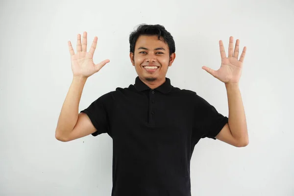 笑着或快乐的亚洲年轻人 双手高举 身穿黑色马球T恤 背景为白色 — 图库照片