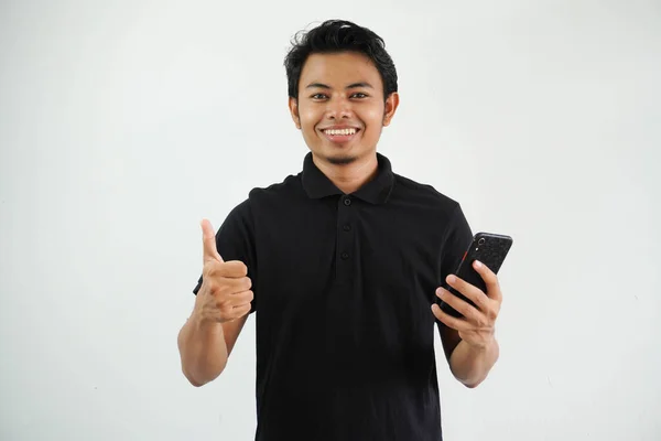 Uśmiechnięty Młody Azjata Czarnej Koszuli Polo Trzyma Telefon Komórkowy Robi — Zdjęcie stockowe