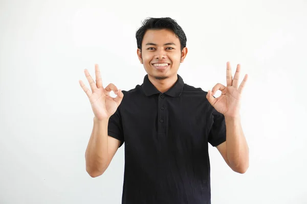 Pemuda Asia Tersenyum Ramah Sambil Memberikan Tanda Tangan Jari Mengenakan — Stok Foto