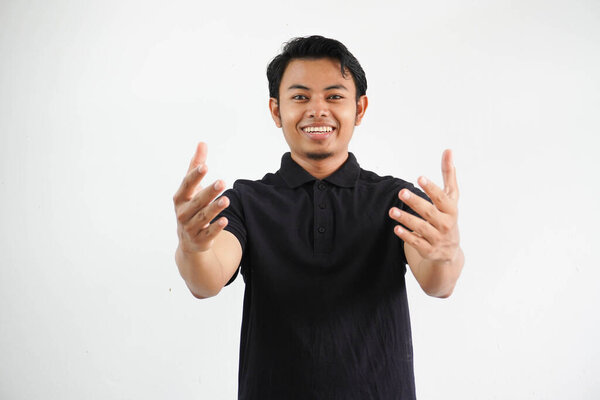 Young Asian man smiling when showing greet gesture wearing black polo t shirt isolated on white background